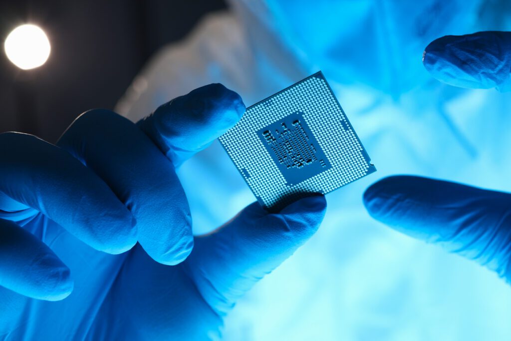 Technician inspecting microchip for fabrication materials